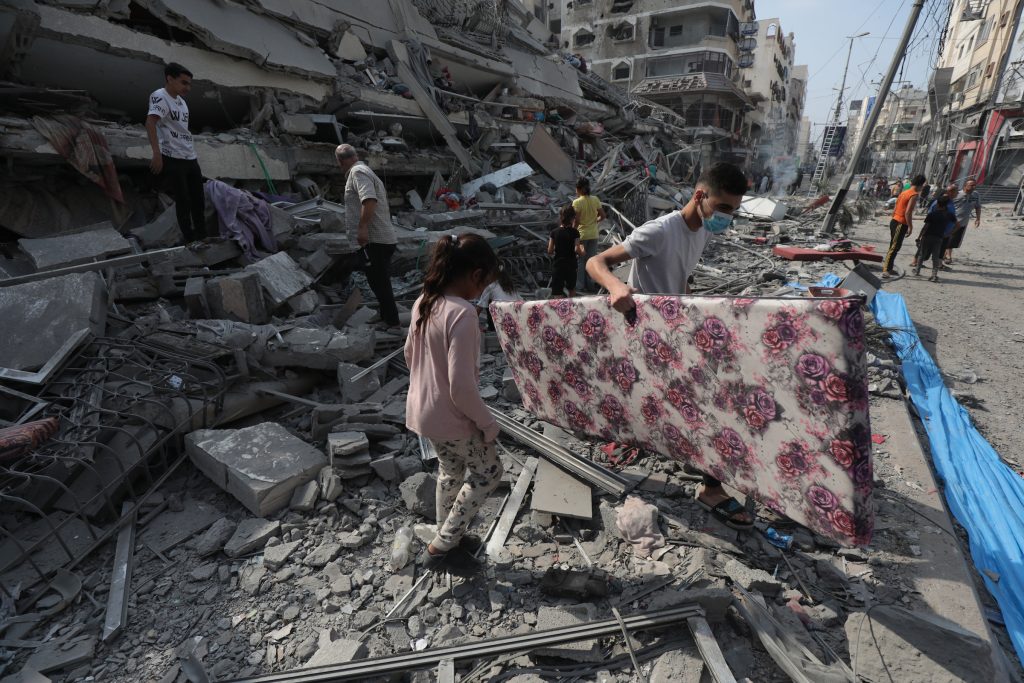 Palestinians inspect the ruins of Aklouk Tower destroyed in Israeli airstrikes in Gaza City on October 8, 2023. The death toll from the devastating Israeli war on the Gaza Strip has risen to 313 since early yesterday morning, with more than 1,990 others injured, according to medical sources. Photo by Naaman Omar apaimages