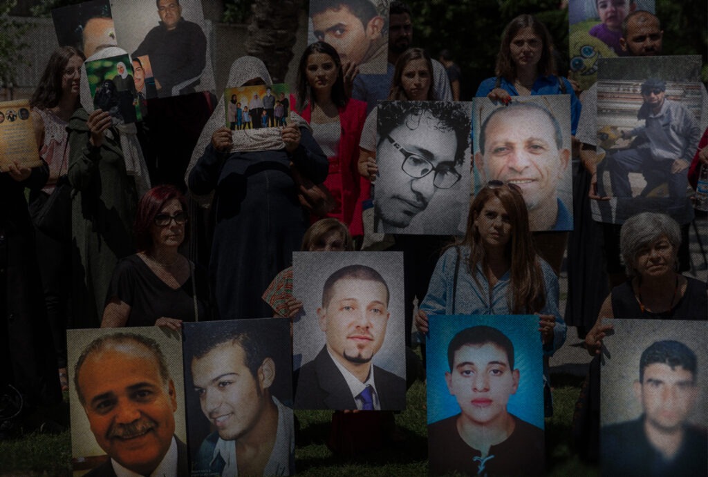 Families of forcibly disappeared persons holding photographs of their missing relatives