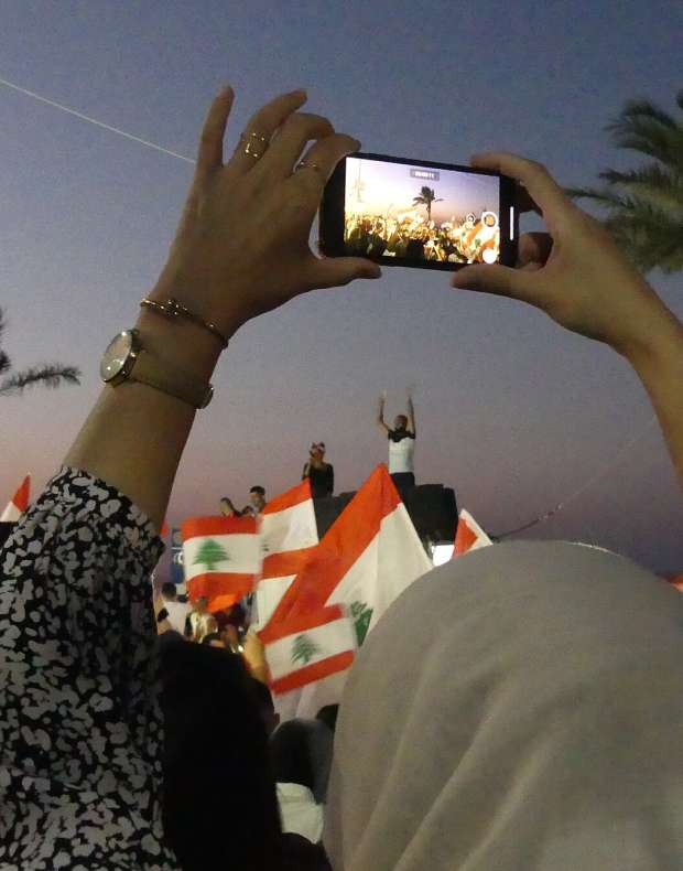 A protester films a demonstration on her phone, Tyre, Lebanon, 2019